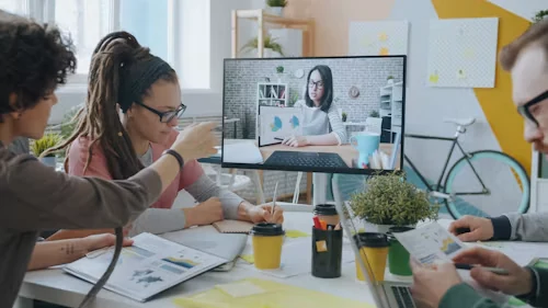 Team meeting with a colleague joining by video call