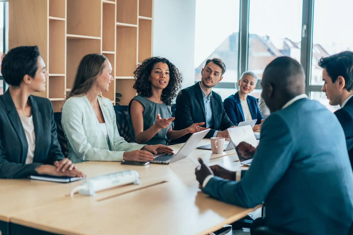 An executive advising a leadership team around a conference table